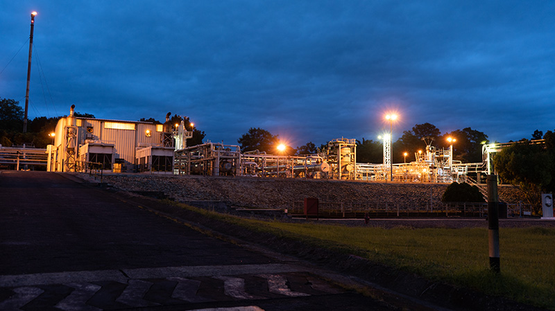 A ground view of a facility at night, illuminated by flood lights