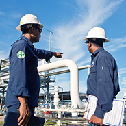 an employee pointing plant equipment out to another employee