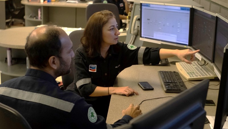 2 workers viewing information on multiple monitors